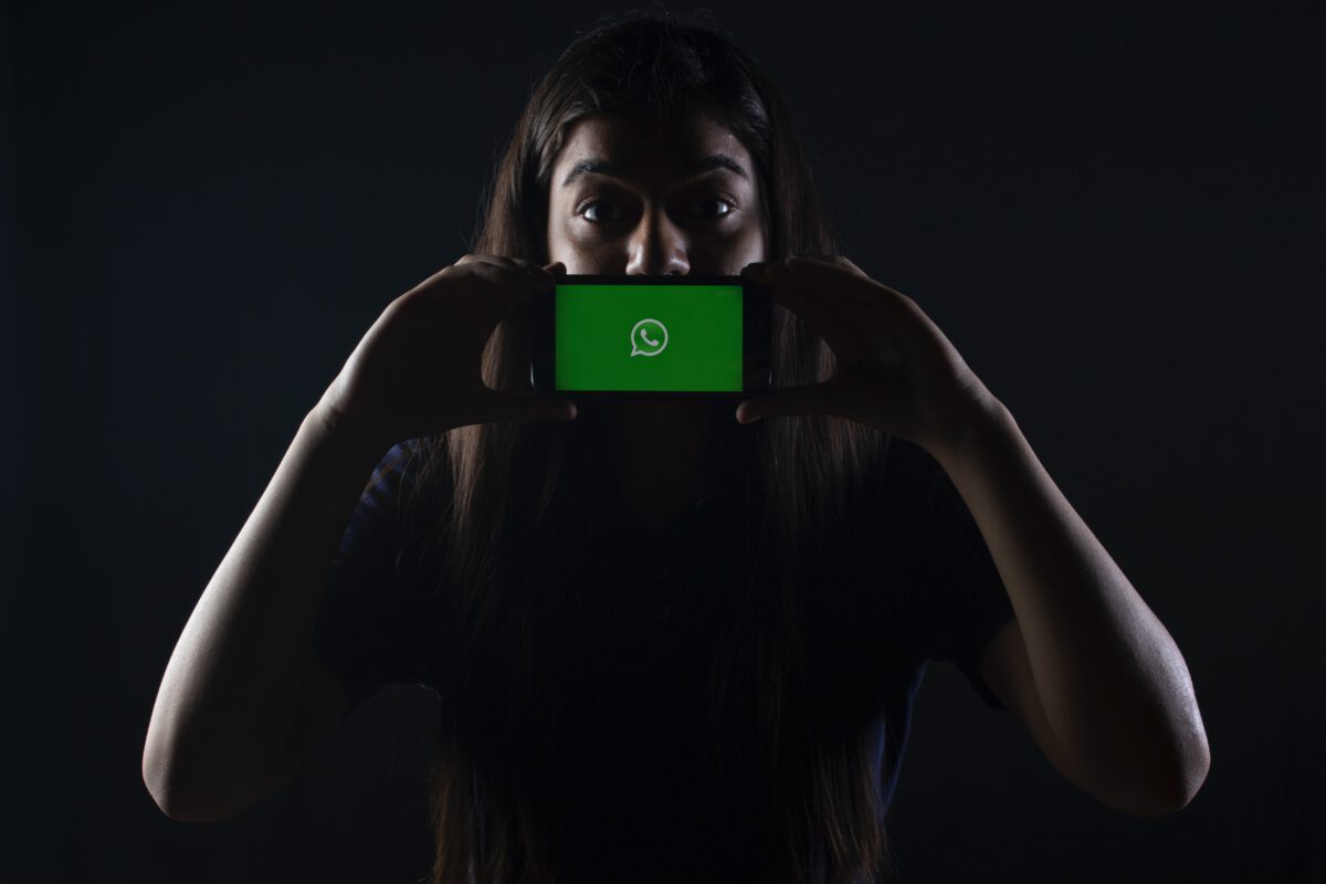 Meisje met haar mobiel waar Whatsapp open staat